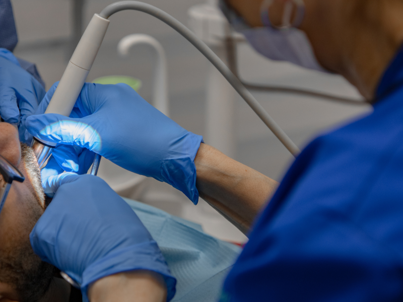 Image d'une dentiste à Montréal lors d'une nettoyage dentaire d'un patient lors de sont rendez-vous chez le dentiste.